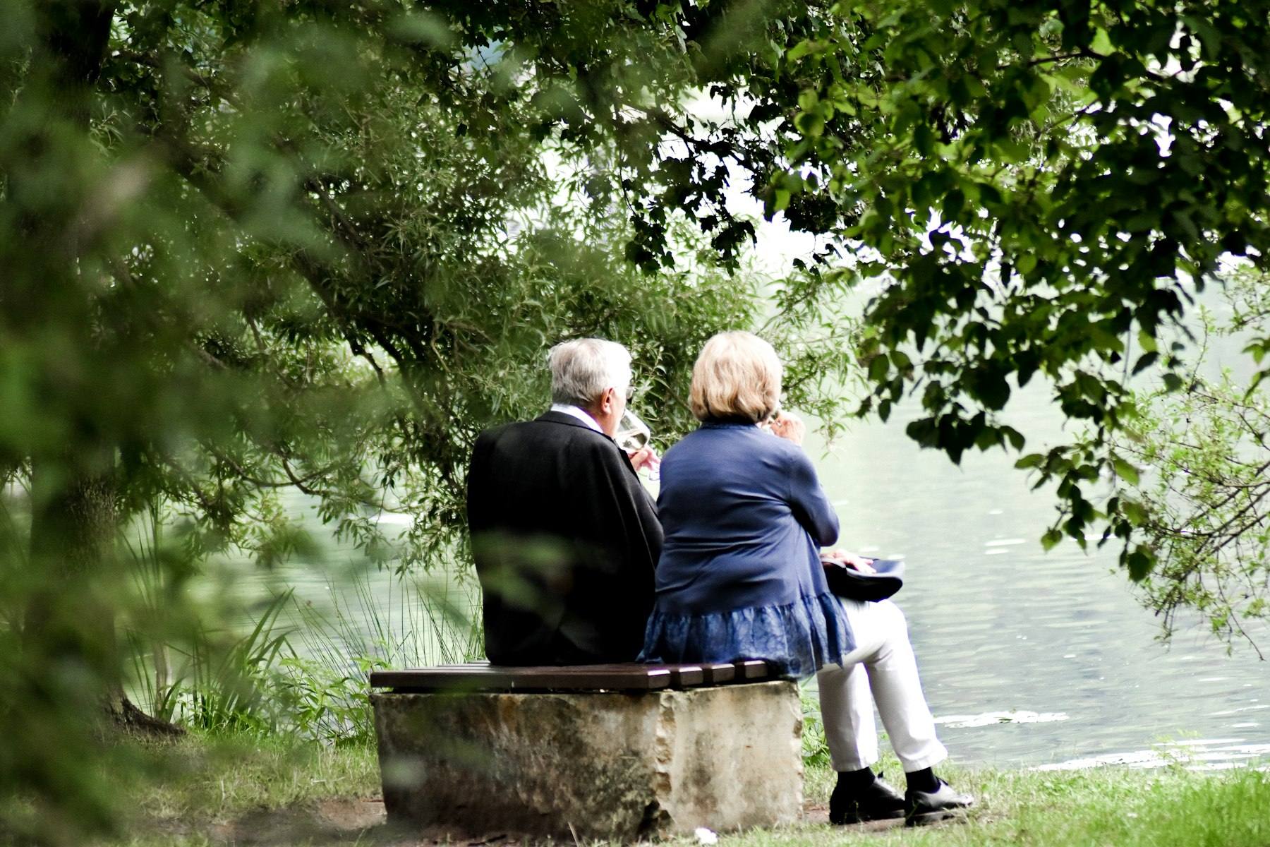 Two people sitting together by the water in quiet conversation